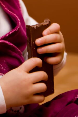 The little girl eats dark chocolateの写真素材