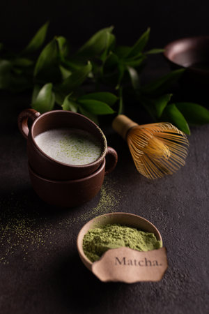 Matcha green tea powder in a cup and whiskey on black backgroundの写真素材