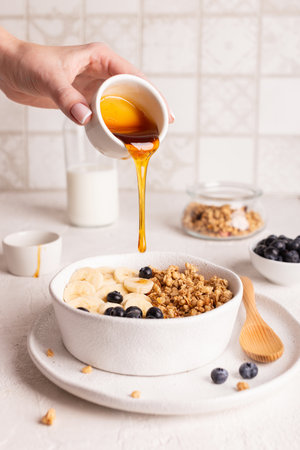 Healthy breakfast. Oatmeal with honey and berries on a light background.の写真素材