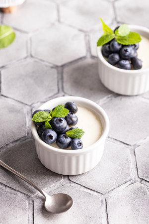 Creme brulee with fresh blueberries and mint on a gray background.の写真素材