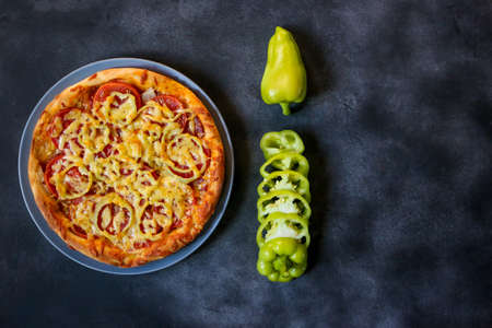 vegetarian pizza and green peppers on dark backgroundの写真素材