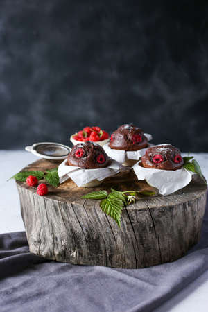 chocolate muffins with raspberries on a dark backgroundの写真素材