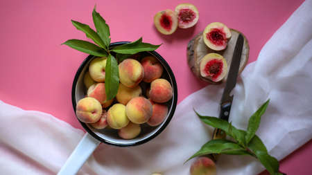 juicy peaches on a pink background and white clothの写真素材