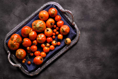 harvest of homemade tomatoes on a dark backgroundの写真素材