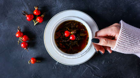 hot black tea with rose hips on a dark backgroundの写真素材