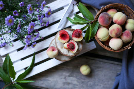 sliced homemade peaches and a knife on a wooden trayの写真素材