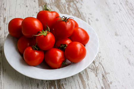 bright red tomatoes on a white plateの写真素材