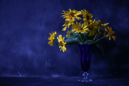 yellow flowers in a blue vaseの写真素材