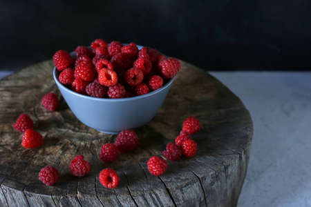 bright homemade raspberries in a plate on a wooden background