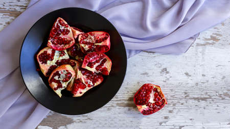 bright and juicy pomegranate on a plateの写真素材