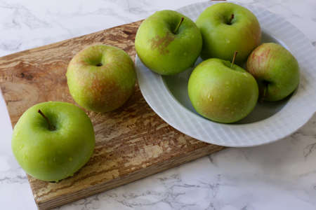 green, healthy apples in a white plateの写真素材