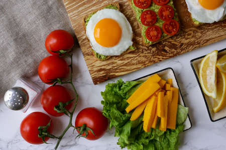toast with avocado and scrambled eggs with tomatoの写真素材