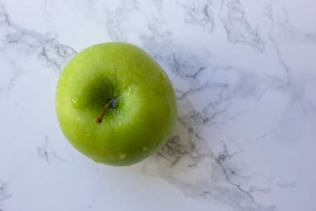 green healthy apple on white marble tableの写真素材
