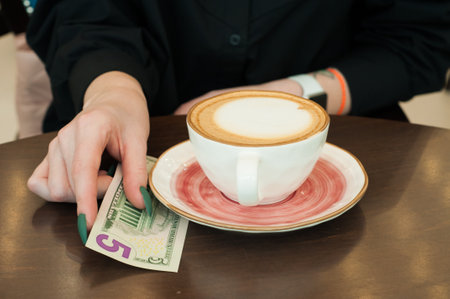 Girl leaves a tip for coffee in a restaurant, close-upの写真素材