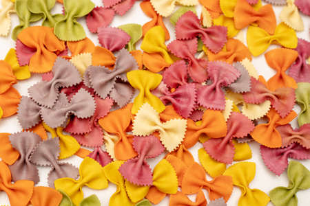 Close-up Photo of colorful Italian pasta background. Traditional Italian food, joyful and Various colors of bow tie farfalle pasta. Top view.の写真素材
