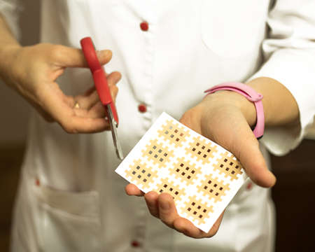 Female hands close-up sticks a patch on their face against aging. Tape for facelift with kinezio....