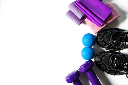 Sports equipment on white background, sneakers, dumbbells, sports ribbons. Fitness kit. Top view. Isolated. Women's set for Pilates, training at home, in gym. Copy space. oncept of healthy lifestyleの写真素材