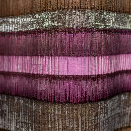 The texture of the fabric on the clearance strip. The canvas is compressed or corrugated. Strip. Gray pink, purple. Close-up photo. For fabric and curtain stores, decoratives materialsの写真素材