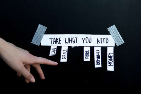 ad with the inscription Take what you need. A woman's caucasian hand reaches for one of the words to...