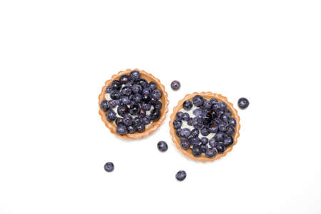 Delicious fresh dessert tartlet of shortbread decorated with fresh blueberries among berries. The concept of baking bakery, sweet food. Close-up photo, isolated, copy space. Top viewの写真素材