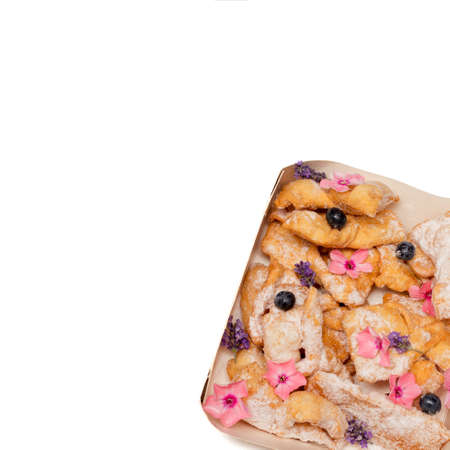 Crunchy brittle straws twigs cookies sprinkled with powdered sugar decorated berry flowers. Homemade baking. Concept of bakery, aesthetic food serving. Sweet life. Close-up Photo. Copy space. Isolatedの写真素材