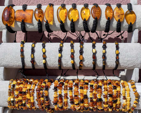 Amber bracelets on the store counter. The stone shimmers in the sunlight. Jewelry, Antiques, natural stone products. Close up photoの写真素材
