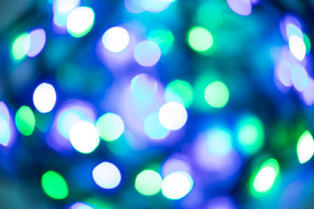 Horizontal abstract bokeh background of evening festive fresh lights in blue, violet and green round shape lights. The concept of Christmas, New Year. Colors of night waterの写真素材
