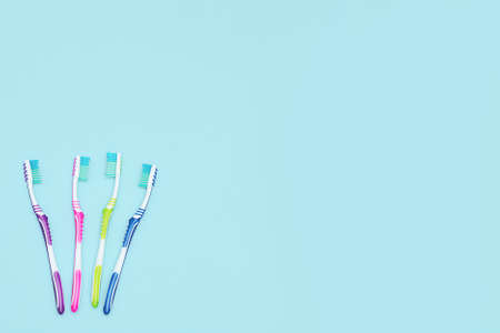 Set of tooth brushes and copy space. A group of colorful toothbrushes. Copy Space for text. Flat lay on blue backgroundの写真素材
