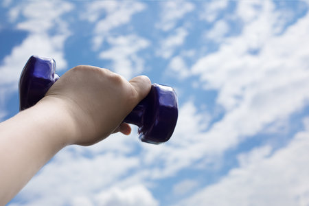 kettlebell against sky with cloud in hand, copy spaceの写真素材