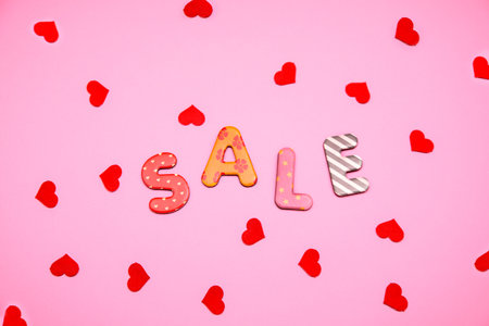 Valentine's Day sale cut out letters with heart shape on pink backgroundの写真素材