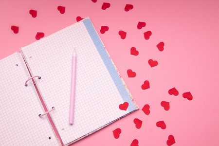 Blank is open. Notebook with pen and little hearts on pink background . Business, school and...