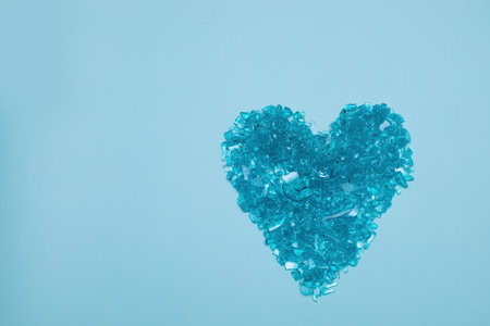 Heart from broken glass on blue background. Concept of broken heart made of shards. Valentine's day. Copy spaceの写真素材