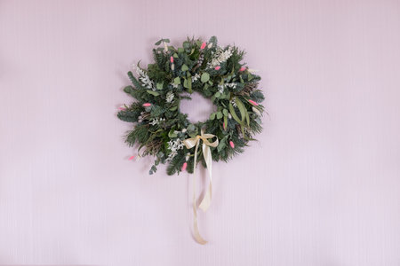 spring decorative easter wreath with satin ribbon on pink wallの写真素材