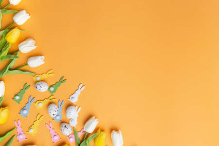 Easter bunny and tulips orange background view copy space concept springtime greeting card...