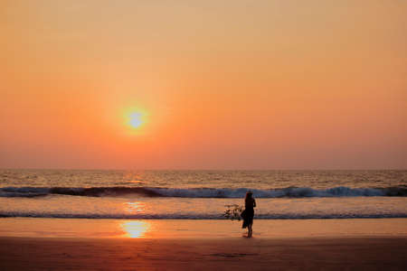 Focus on silhouette woman sunset beach holiday vacation lifestyle freedom conceptの写真素材