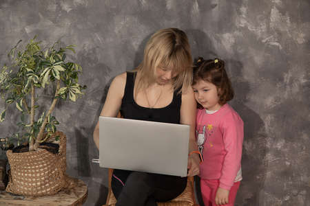 Close up photo of mother and daughter using laptop at home, e-commerce concept, study onlineの写真素材