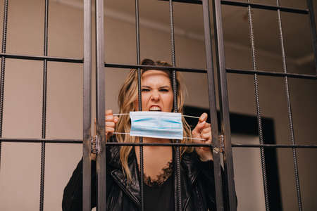 woman rips off a protective mask from face.  , concept domestic violence depression. focus on mask