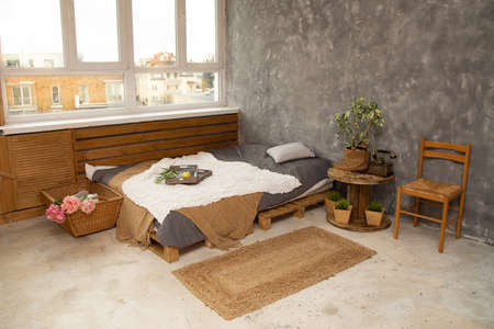 Gray and gold, modern bedroom interior with king-size bed decorated with cushions and blankets