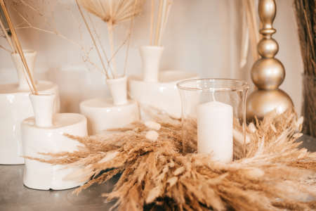 Natural light interior decor, table, candlesticks with candles, dry herbsの写真素材