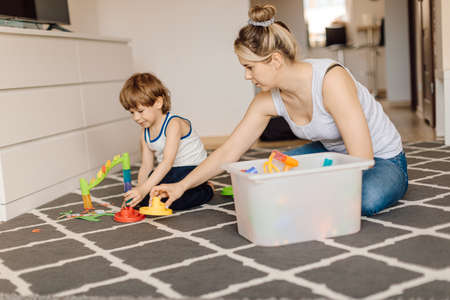 Mom plays while sitting on floor with boy 3 years old. Mom-son relationship. Development and training of design skills.の写真素材