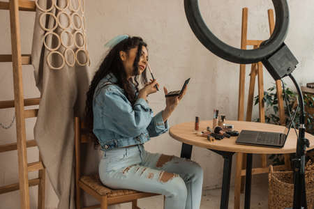 Popular blogger young woman applies makeup live. blogging and social media concept.の写真素材
