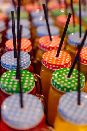 Jars with smoothies, closed with polka-dot lids and straws. Beauty and health. Proper nutrition.