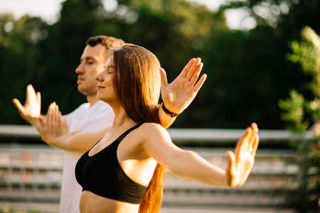 Young couple man and woman exercising together in the eveningの写真素材