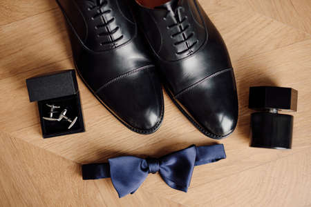 men accessories, black shoes, blue butterfly, perfumes. Concept of a wedding holiday, gathering of groom.の写真素材