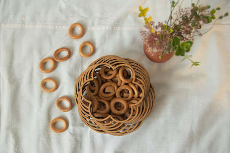 Drying bagels in an authentic carved wooden box on a tablecloth, an authentic lifestyle photo in neutral colors, composition. High quality photoの写真素材