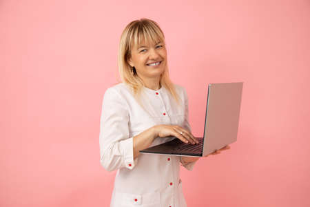 Friendly blonde cosmetologist invites you to visit her beauty salon and get professional care and lot of fun. Beauty and health. Small business. Beauty salons. Freshness and youthfulness of skin.の写真素材