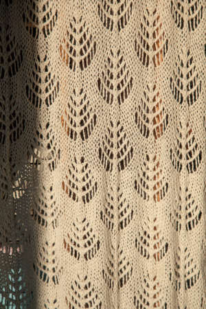 Knitted handmade blanket scarf plaid with beige patterns, close-up photo, full frame, front view. Great background of natural wool, cotton. High quality matirealの写真素材