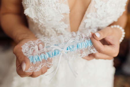 Women hands holding wedding garter. Concept of women's underwear, romance and innocence. unrecognizable people. High quality photoの写真素材