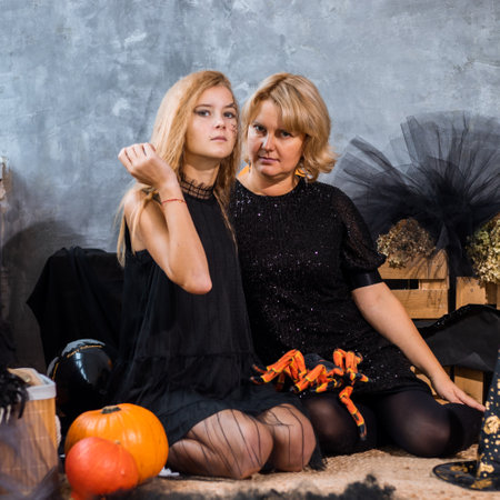 Mom with children girl daughter 12 years among decor with orange and black tones for halloween have fun and spend timeの写真素材