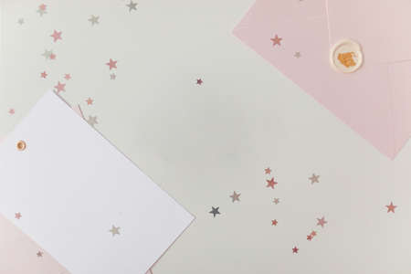 Photo of Blank white card in pink envelope isolated woodden color background with glitter stars, vaucher, gift certificate. White and pinkの写真素材